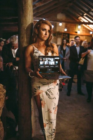 Gledswood Wedding - A wedding guest holds a laptop as the couple livestream their wedding ceremony