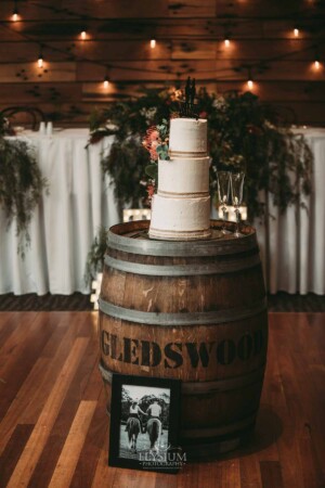 Gledswood Wedding - Three tier wedding cake sits on top of a wine barrel