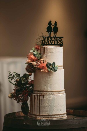 Gledswood Wedding - Wedding cake adorned with flowers at a Gledswood estate reception