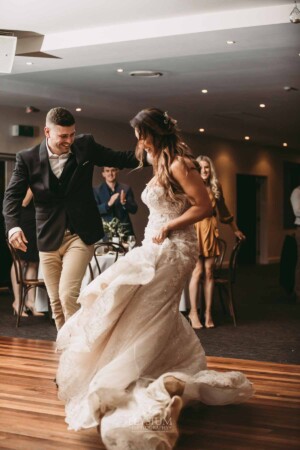 Gledswood Wedding - A groom twirls his bride as they enter their Gledswood wedding reception