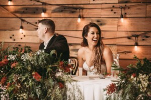 Gledswood Wedding - Bride and groom sitting that the bridal table during the wedding reception