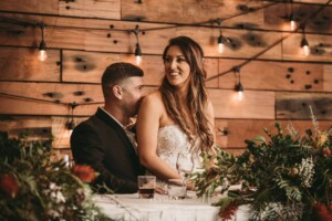 Gledswood Wedding - A bride and groom laugh as they listen to speeches at the wedding reception