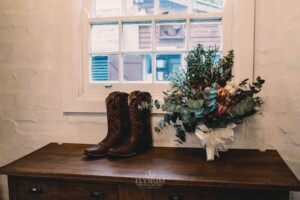 Gledswood Wedding - Bridal bouquet set next to the brides cowgirl boots for the wedding