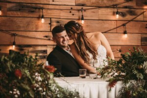 Gledswood Wedding - A bride and groom laugh as they listen to speeches at the wedding reception