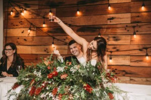 Gledswood Wedding - A bride and groom toast the speaker during speeches at the wedding reception