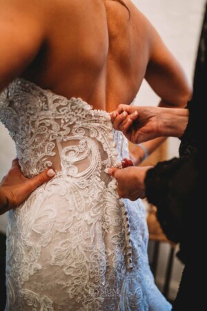 Gledswood Wedding - The mother of the groom helps the bride into her wedding gown