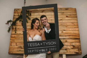 Gledswood Wedding - Bride and groom pose in their wedding photo booth, holding up their ring fingers