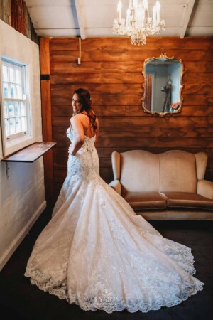 Gledswood Wedding - A bride stands next to the window in the Gledswood bridal suite