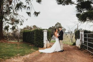 Gledswood Wedding - A bride and groom stand on the dirt driveway at Gledswood before the wedding