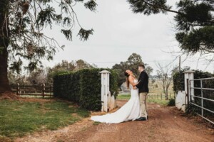 Gledswood Wedding - A bride and groom stand on the dirt driveway at Gledswood before the wedding