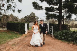 Gledswood Wedding - A bride and groom walk up the dirt driveway at Gledswood to their wedding