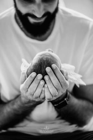 Newborn session - A fathers hands gently holding his baby's head