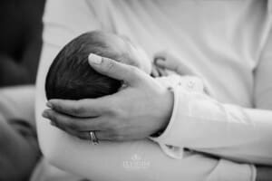 Newborn session - A mothers hand cradles her baby's head