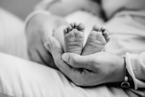 Newborn session - A mothers hand holding her newborn baby's tiny feet