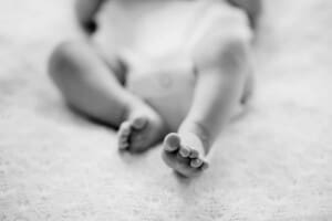 Newborn session - a baby laying on a bed with tiny toes