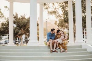 Family Photographer - Parents hug their daughter as they sit on the Balmoral Rotunda steps