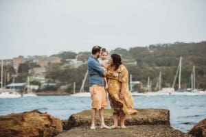 Family Photographer - Parents cuddle their little girl between them