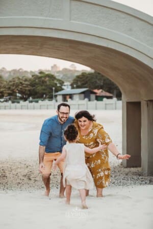 Family Photographer - Parents wait for their daughter to run and hug them