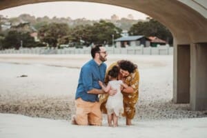 Family Photographer - Parents wait for their daughter to run and hug them