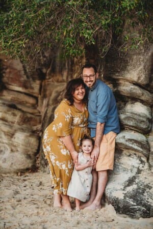 Family Photographer - A little girl cuddles her parents