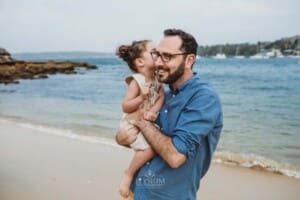 Family Photographer - A little girl kisses her daddy on the cheek