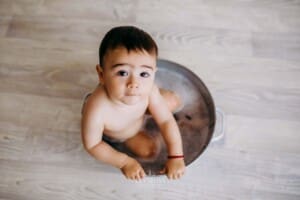 Baby boy enjoys a bubble bath after his messy cake smash session