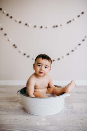 Baby boy enjoys a bubble bath after his studio cake smash session