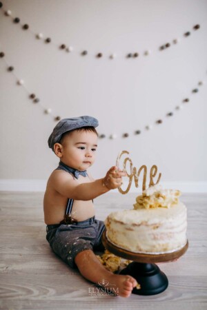Baby boy pulls the cake topper off his first birthday cake