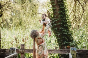 Family Photographer - A mother lifts her baby girl above her