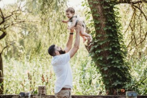 Family Photographer - A father lifts his little girl above him