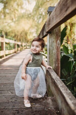 Family Photographer - A little girl stands on a boardwalk