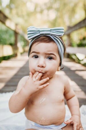 Family Photographer - A little girl sucks cake icing from her fingers