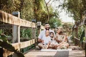 Family Photographer - A family sit cuddling on a boardwalk