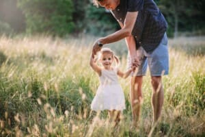 Family Photographer - A dad twirls his little girl like a ballerina in long grass
