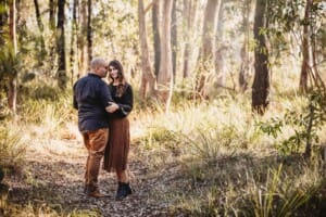 Family Photographer - A couple embrace, standing on a dirt path