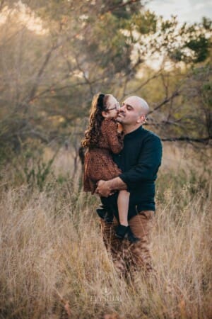 Family Photographer - a little girl kisses her dad on the cheek