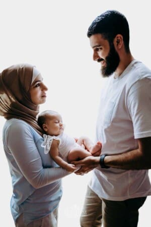 Newborn session - Parents stand holding their baby girl in their arms