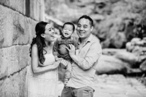 Family Session - Parents hug their giggling baby boy between them
