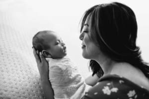 Newborn session - a mother holds her newborn baby in her arms
