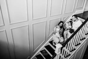 Family session - parents sitting on the stairs hugging their kids