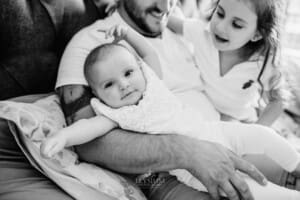 Family session - a father holds his baby girl in his arms