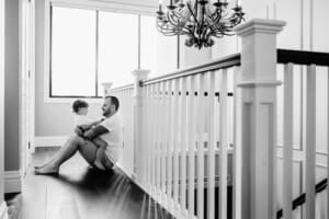 Family session - a dad hugs his little boy, sitting in his lap