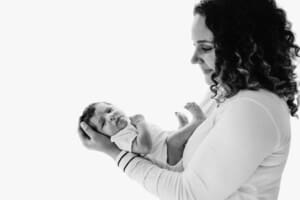 Newborn session - a mother holds her baby boy in her arms