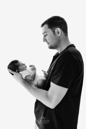 Newborn session - a father holding his baby son in his arms
