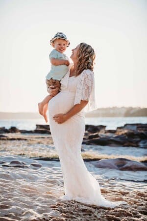 Maternity session - a pregnant woman hugs her little boy on her hip