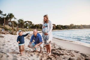 Maternity session - a little boy blows bubbles to his pregnant mamma