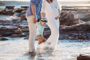 Maternity session - a little boy splashes his feet at the beach