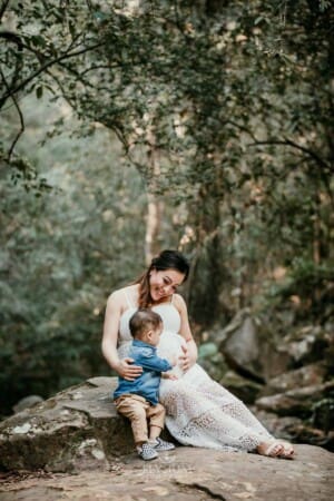 Maternity Session - a little boy pats his mothers pregnant belly