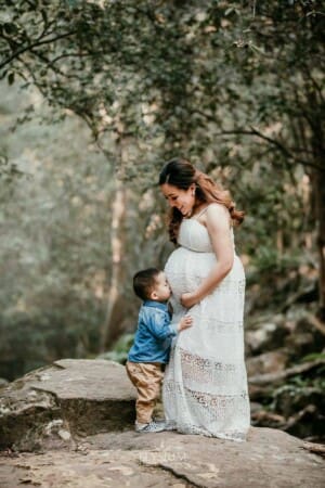 Maternity Session - a little boy kisses his mothers pregnant belly