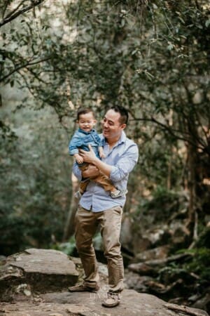 Family Session - a father hugs his little boy, standing in the bush